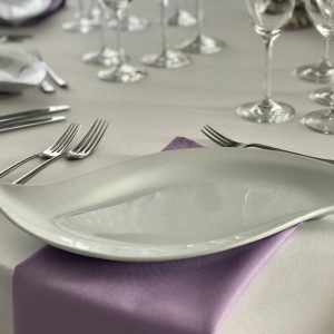 Violetinė, alyvos spalvos stalo servetėlė 50x50cm. Nuomos kaina 0,5 €.