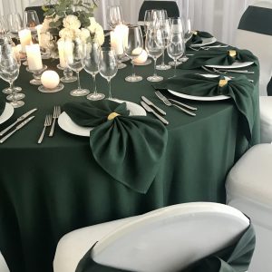 Tamsiai žalios spalvos stalo servetėlė 50x50cm. Nuomos kaina 0,5 €.