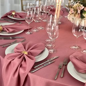 Tamsiai rožinės spalvos stalo servetėlė 50x50cm. Nuomos kaina 0,5 €.